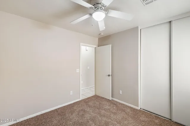 an empty room with a window and a fan