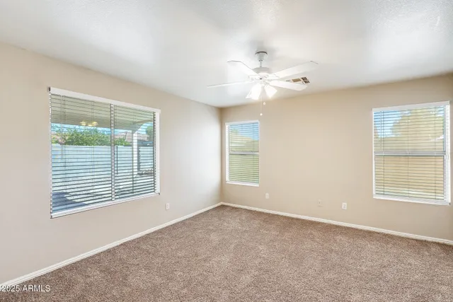 an empty room with a chandelier fan and closet area