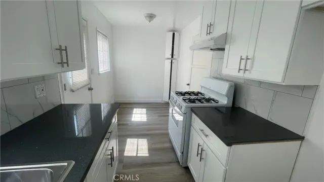 a kitchen with stainless steel appliances granite countertop a sink a stove and a refrigerator