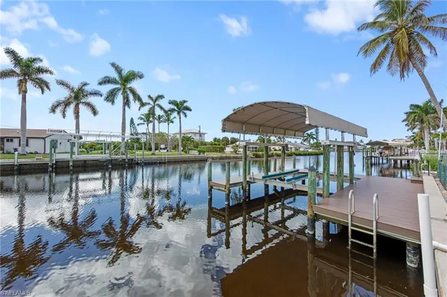 a view of a lake with a table and chairs under an umbrella