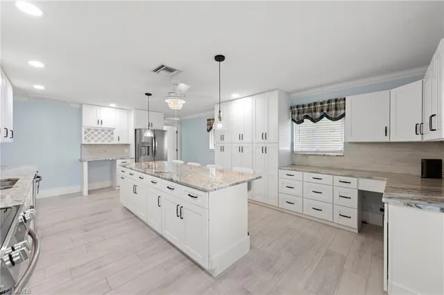 a large kitchen with cabinets a sink a window and stainless steel appliances