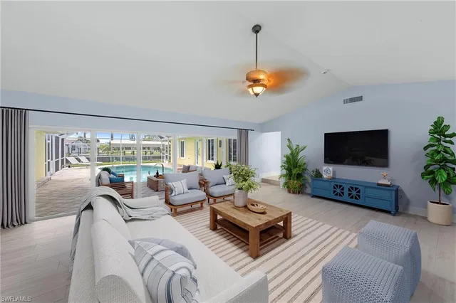 a living room with furniture a chandelier and a flat screen tv