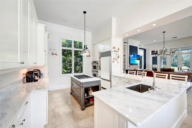 a kitchen with a sink a stove and chairs
