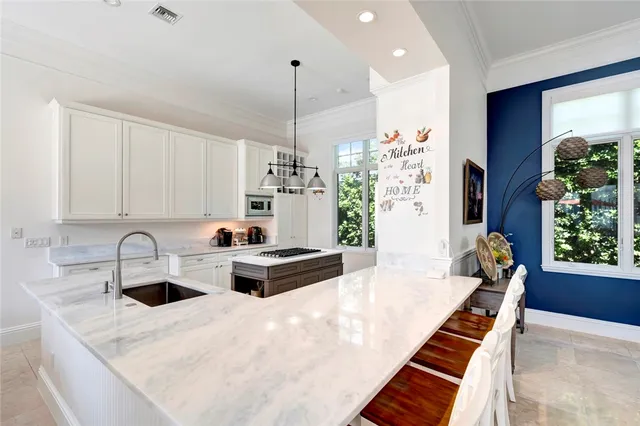 a kitchen island with a stove a sink and a refrigerator