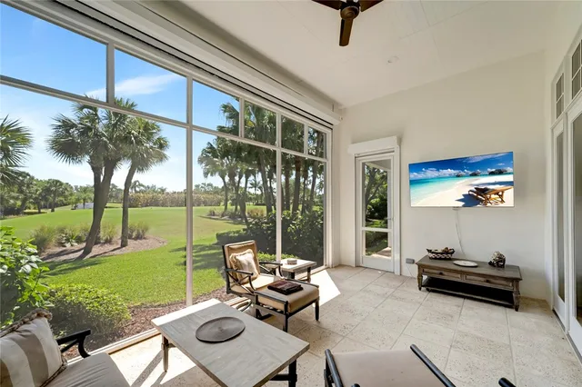a living room with patio furniture and garden view