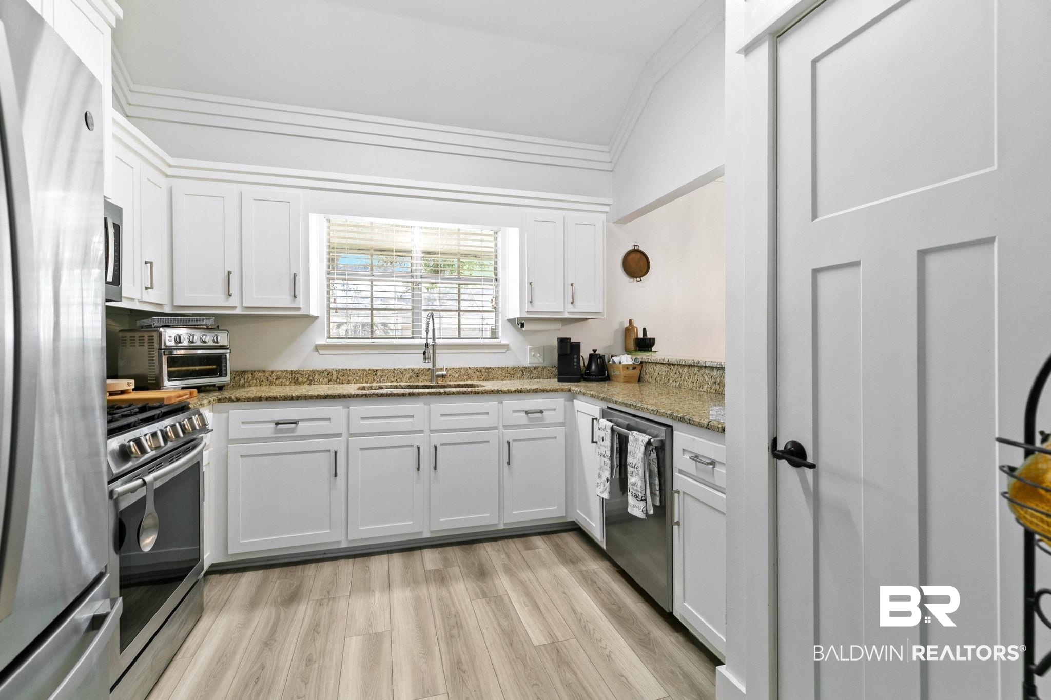 520 Juniper Place Drive Foley, AL 36535 - Photo 12 of 35 Kitchen featuring white cabinetry, granite countertops, stainless steel appliances, wood-finish flooring, and a window above the sink