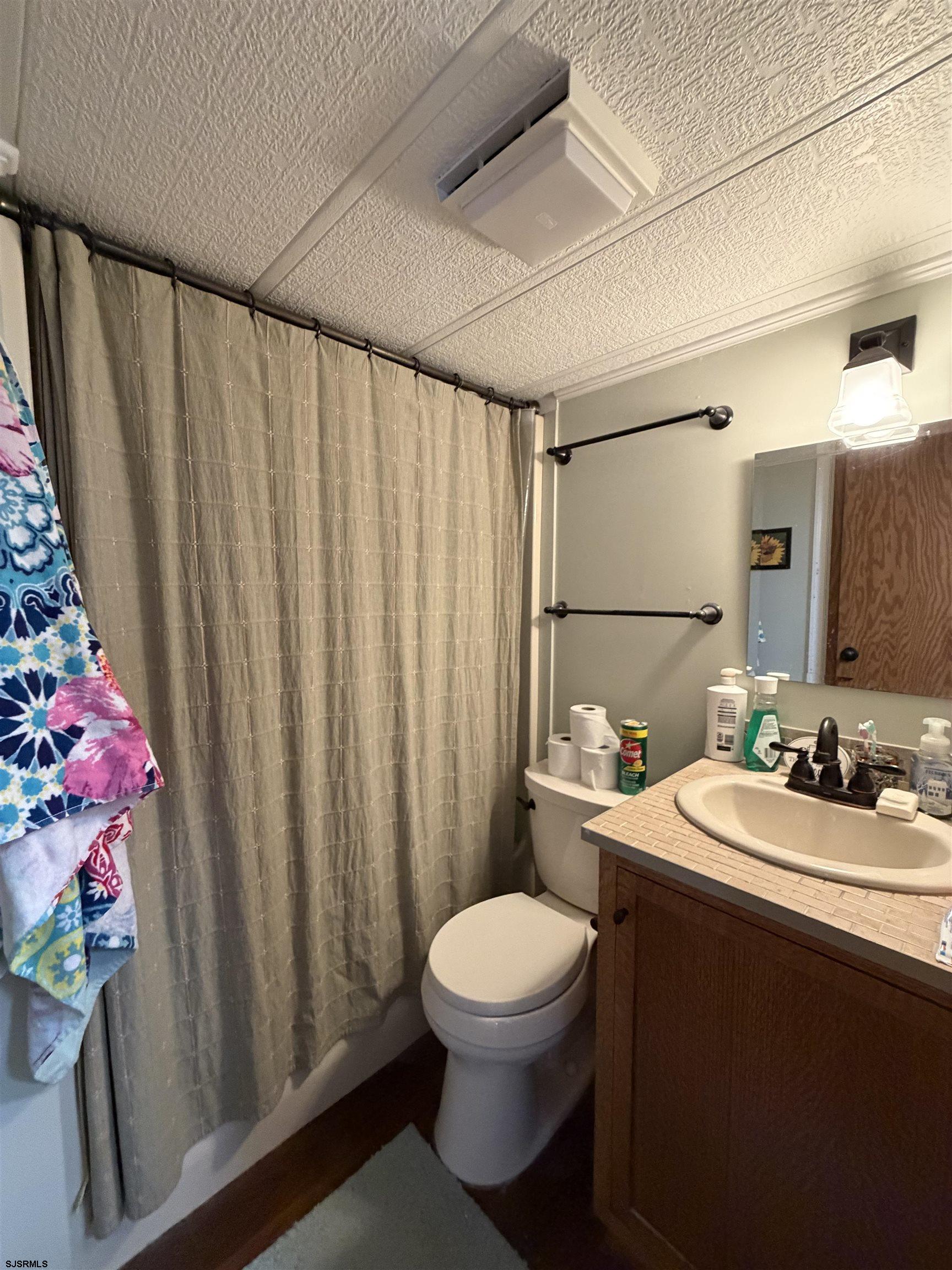 631 Chestnut Neck Road Port Republic, NJ 08241 - Photo 4 of 13 a bathroom with a sink a toilet and shower curtain