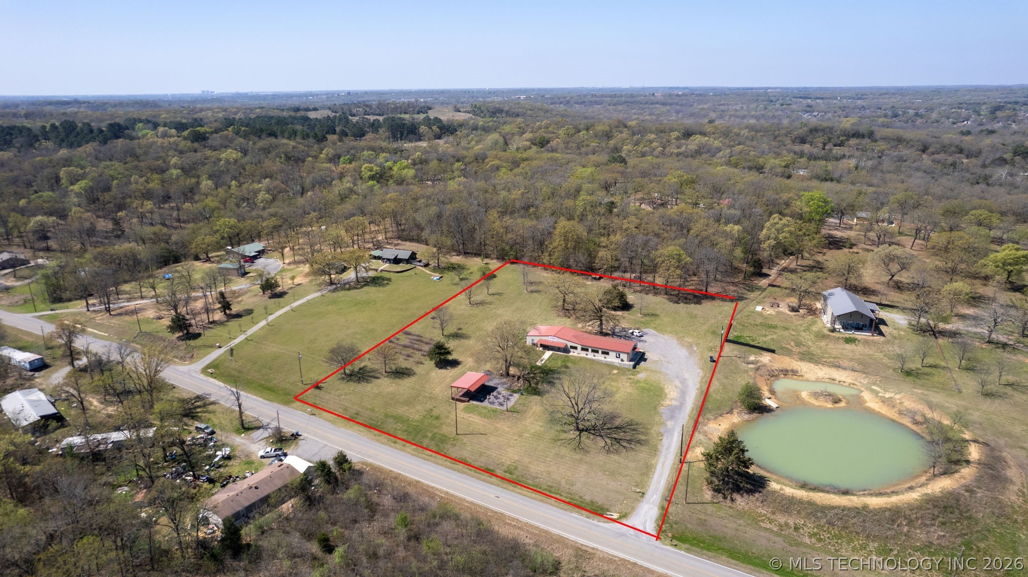 3565 Sawmill Road Caddo, OK 74729 - Photo 32 of 32 Expansive lot featuring a pond, a primary residence with a red roof, and a separate outbuilding