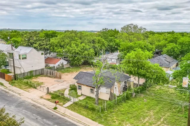 an aerial view of residential houses with outdoor space and trees