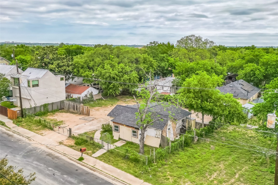 an aerial view of residential houses with outdoor space and trees