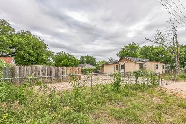 a view of a yard with wooden fence