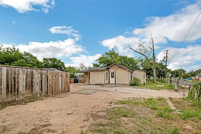 a white house that has tree in front of it