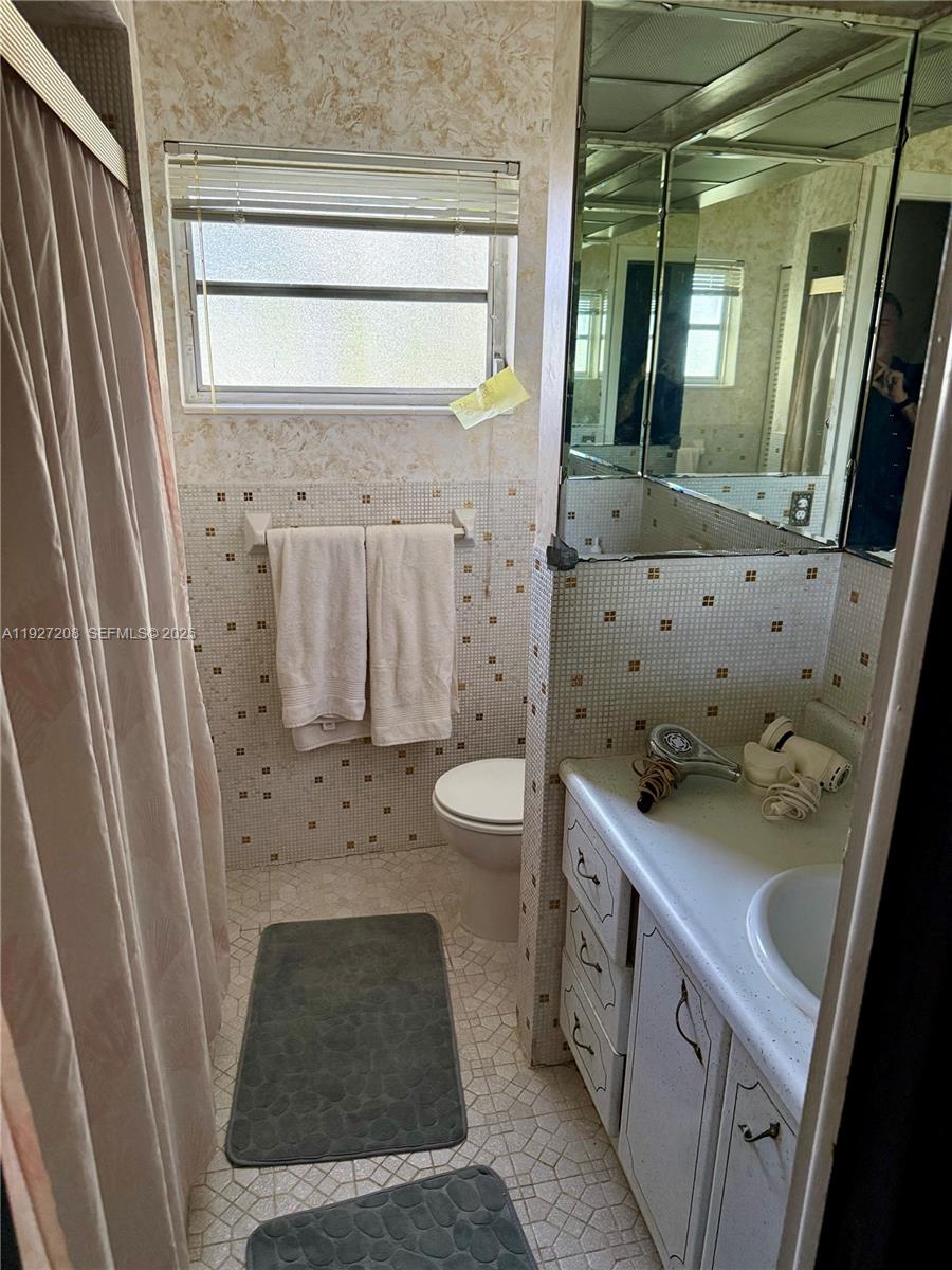 6341 Tamiami Canal Road Miami, FL 33126 - Photo 7 of 13 a bathroom with a granite countertop sink toilet and shower