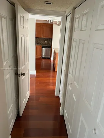 a view of a hallway with wooden floor and staircase