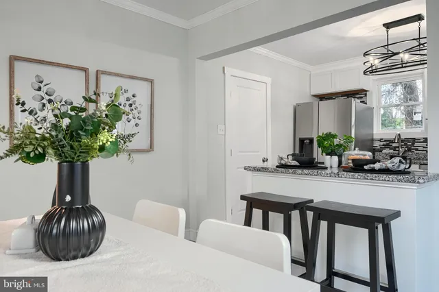 a living room with furniture a chandelier and a potted plant