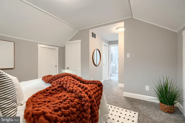 a bedroom with a bed and a potted plant