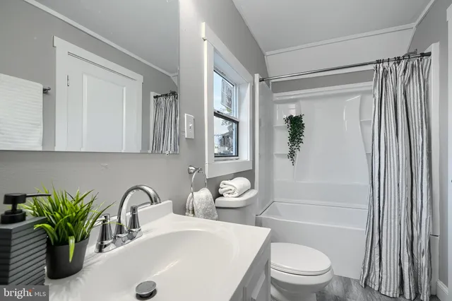 a bathroom with a granite countertop sink a toilet and shower