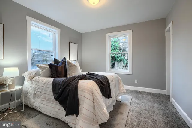 a bed sitting in a bedroom next to a window