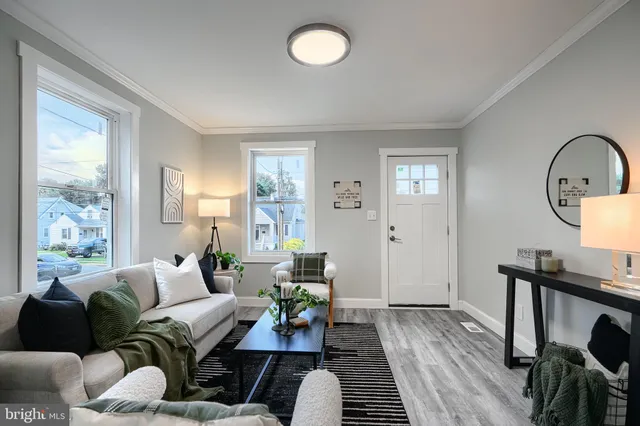 a living room with furniture a window and wooden floor
