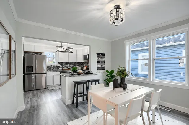 a dining room with furniture large window and wooden floor