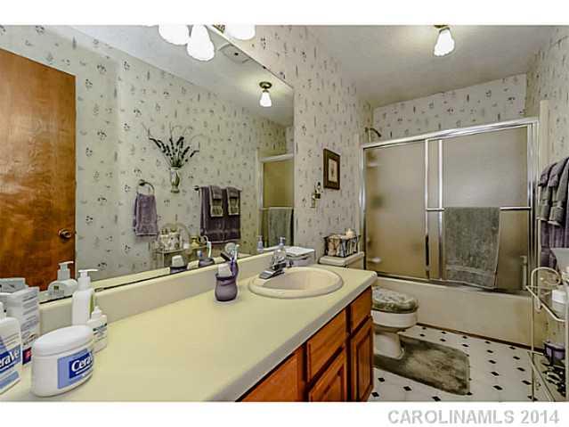 1611 Little Rock Road Charlotte, NC 28214 - Photo 12 of 16 a bathroom with a sink double vanity granite tub shower and a mirror