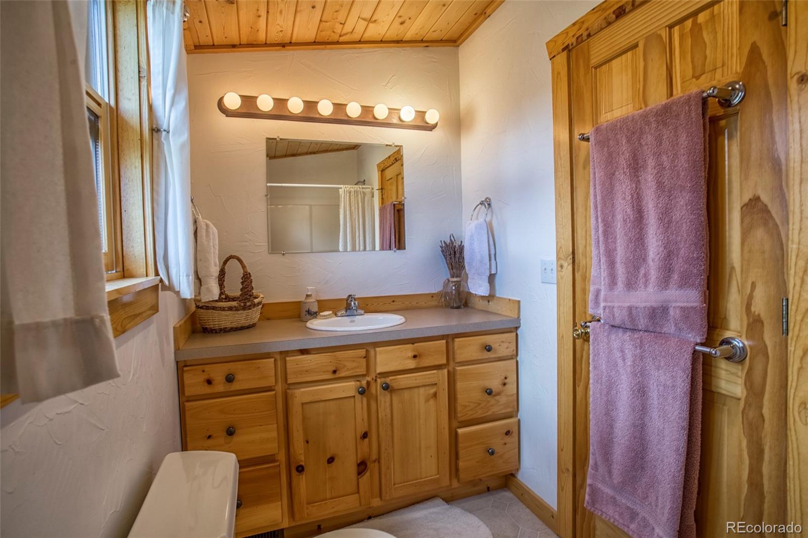 144 Red Cloud Road Como, CO 80456 - Photo 25 of 34 a bathroom with a sink a mirror and a shower