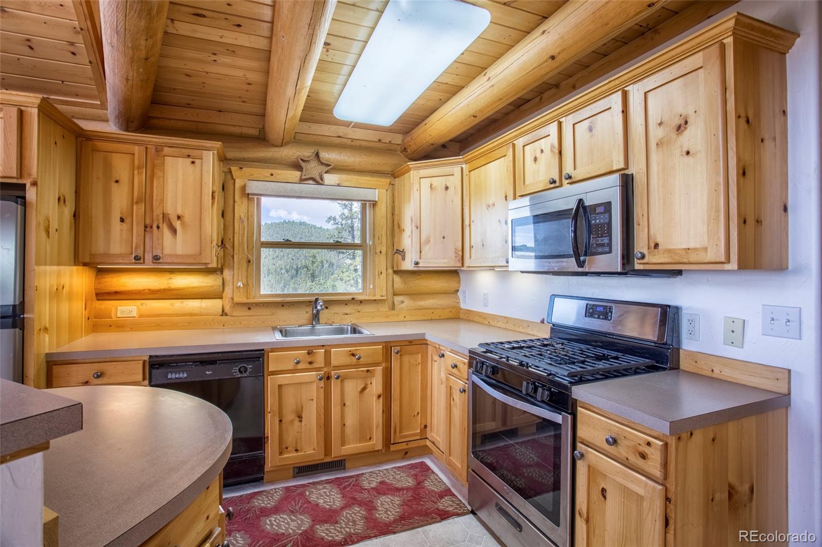 144 Red Cloud Road Como, CO 80456 - Photo 8 of 34 a kitchen with stainless steel appliances a stove a sink and a microwave