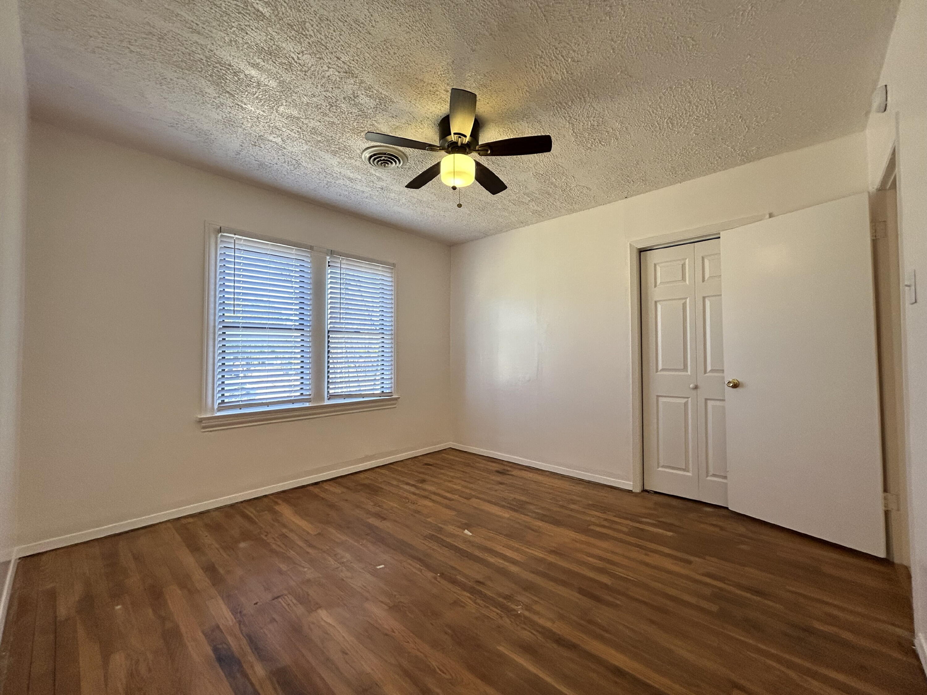 2201 28th Street, Unit FRONT Lubbock, TX 79411 - Photo 13 of 23 wooden floor in an empty room with a window
