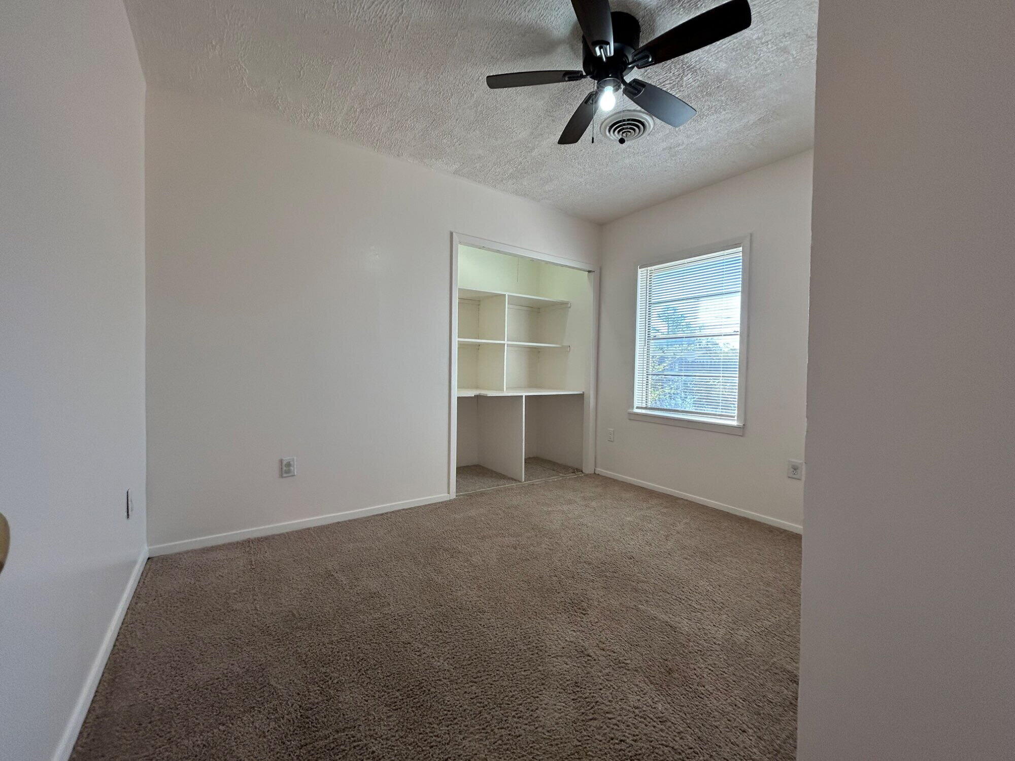 2201 28th Street, Unit FRONT Lubbock, TX 79411 - Photo 18 of 23 an empty room with windows and ceiling fan