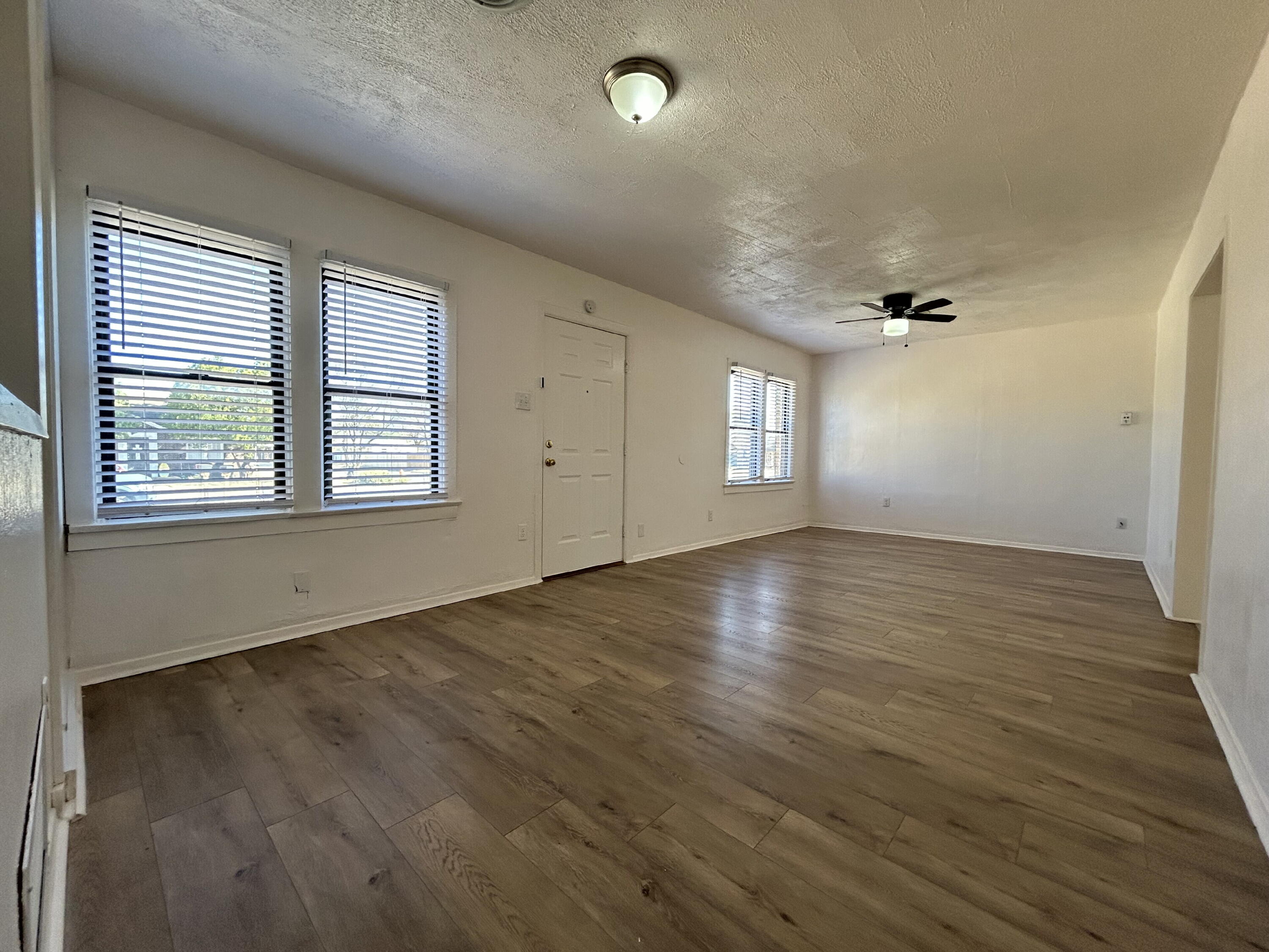 2201 28th Street, Unit FRONT Lubbock, TX 79411 - Photo 4 of 23 an empty room with wooden floor and windows