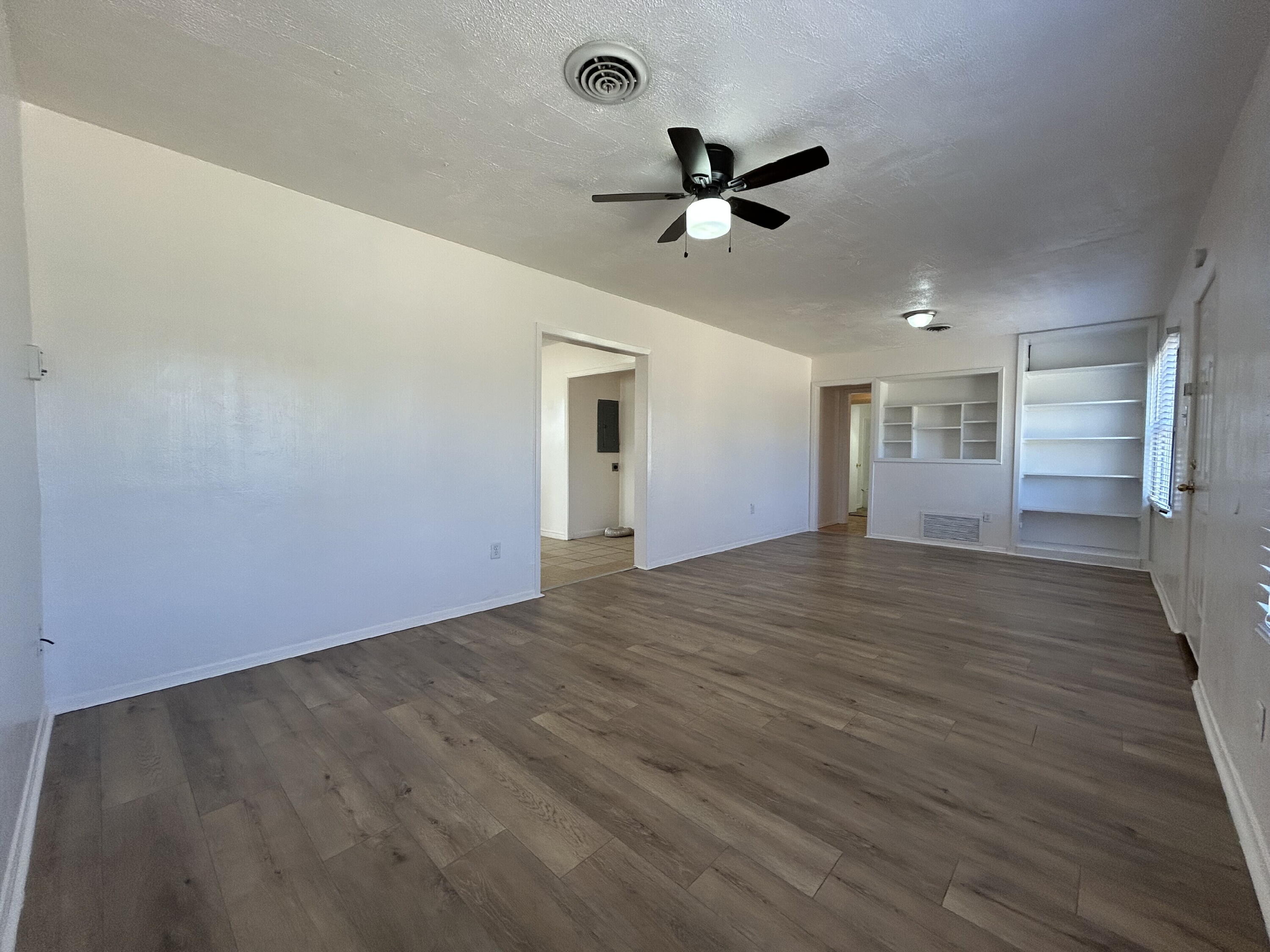 2201 28th Street, Unit FRONT Lubbock, TX 79411 - Photo 5 of 23 a view of empty room with wooden floor and fan