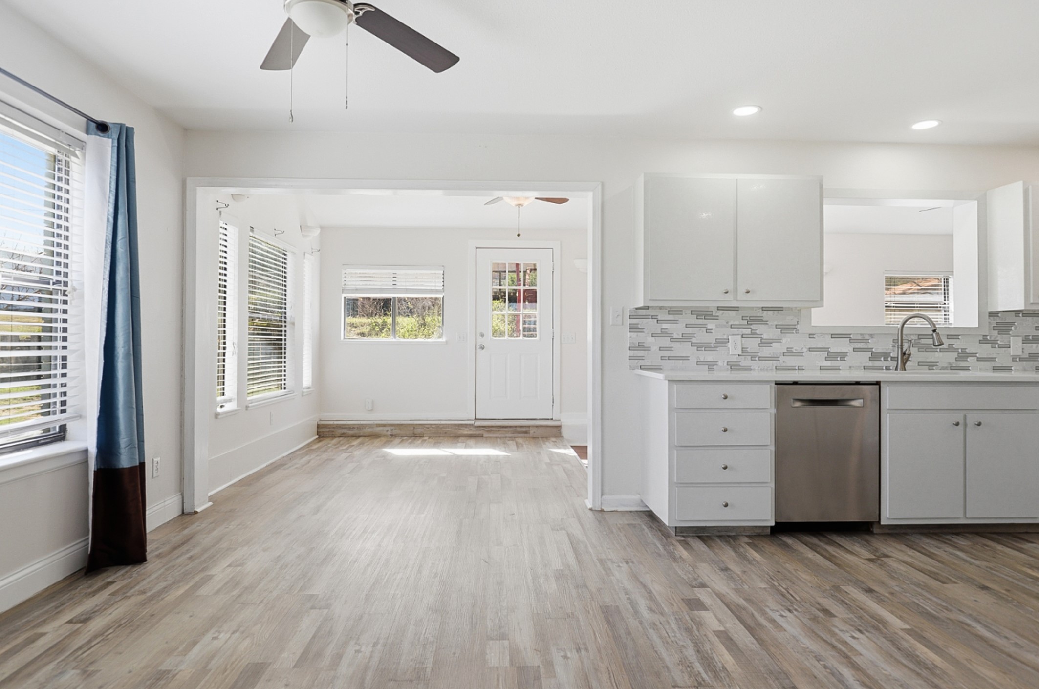 128 Skyview Terrace Leander, TX 78641 - Photo 5 of 23 Eat-in area off the Kitchen. Kitchen shows backsplash, dishwasher, light wood-style flooring, and white cabinets.