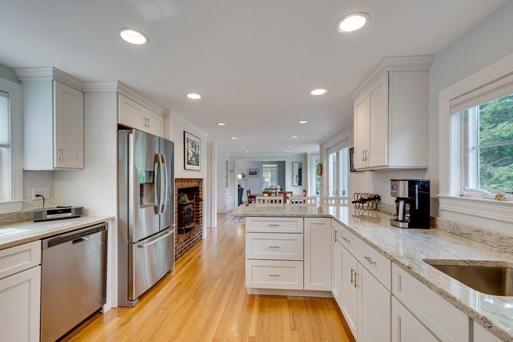 35 Meadowbrook Road Needham, MA 02492 - Photo 11 of 32 a kitchen with stainless steel appliances kitchen island granite countertop a refrigerator oven a sink dishwasher and white cabinets with wooden floor