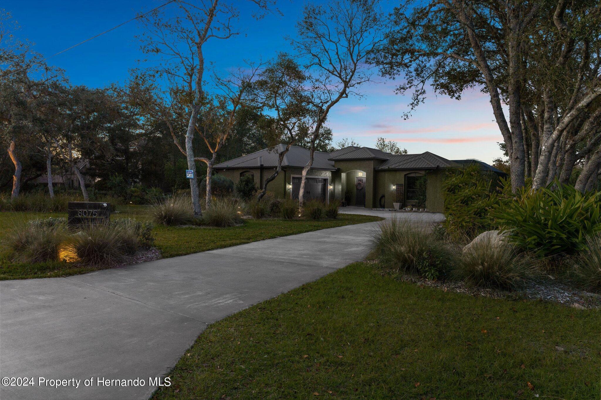 8075 Delaware Weeki Wachee, FL 34607 - Photo 24 of 96 a front view of a house with a garden and a yard