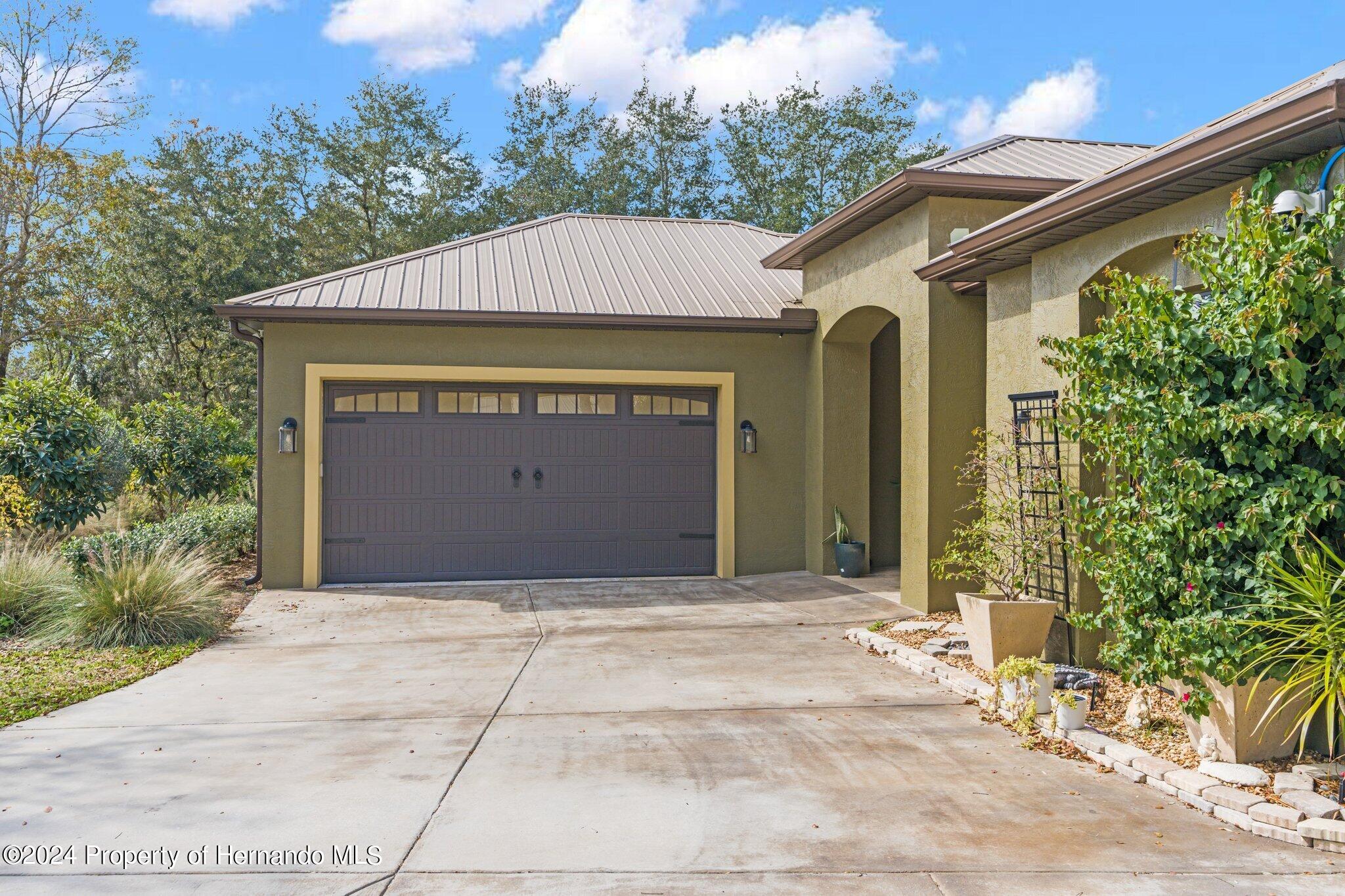 8075 Delaware Weeki Wachee, FL 34607 - Photo 76 of 96 a front view of a house with a yard and garage
