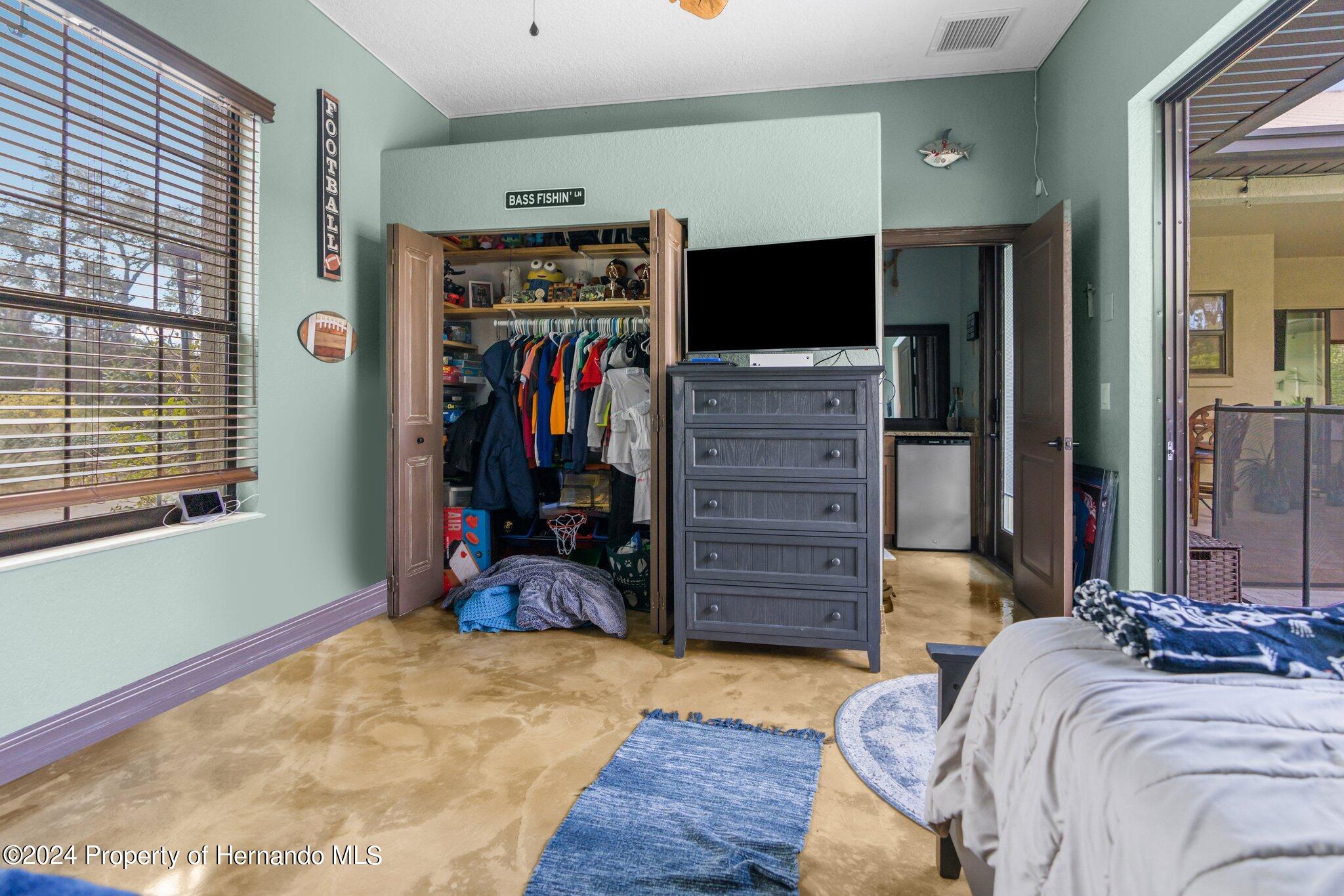 8075 Delaware Weeki Wachee, FL 34607 - Photo 84 of 96 a bed room with a bed and a flat tv screen