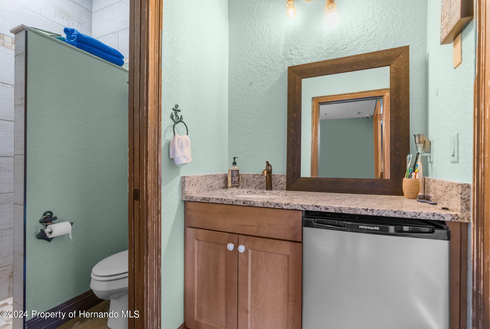 8075 Delaware Weeki Wachee, FL 34607 - Photo 85 of 96 a bathroom with a granite countertop sink and a mirror
