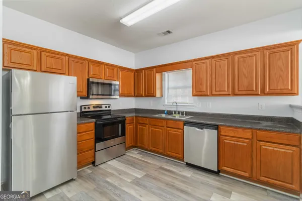 a kitchen with stainless steel appliances granite countertop a refrigerator sink and microwave