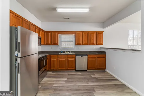 a kitchen with stainless steel appliances granite countertop a refrigerator sink and cabinets