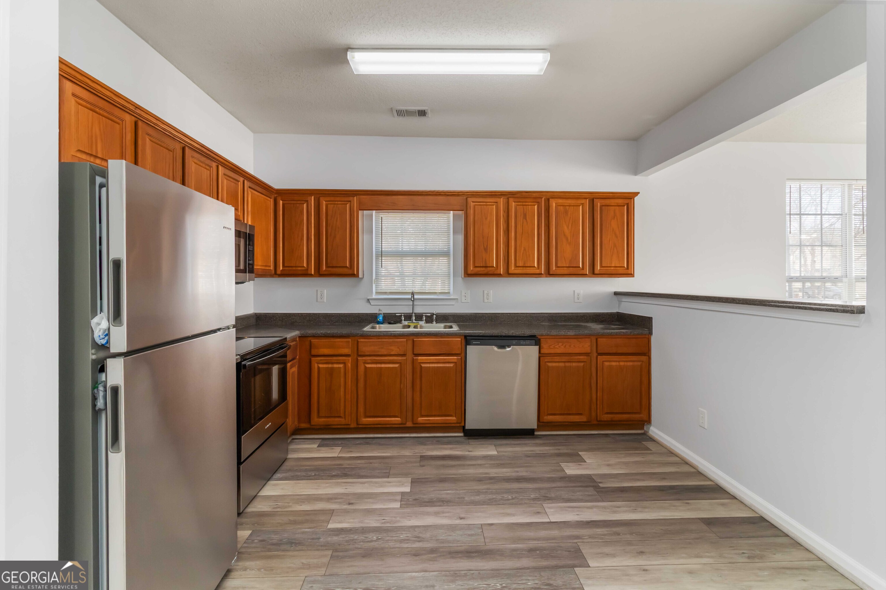 11307 Michelle Way Hampton, GA 30228 - Photo 12 of 30 a kitchen with stainless steel appliances granite countertop a refrigerator sink and cabinets