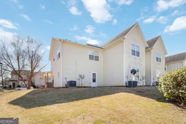 a view of a house with a yard and large tree