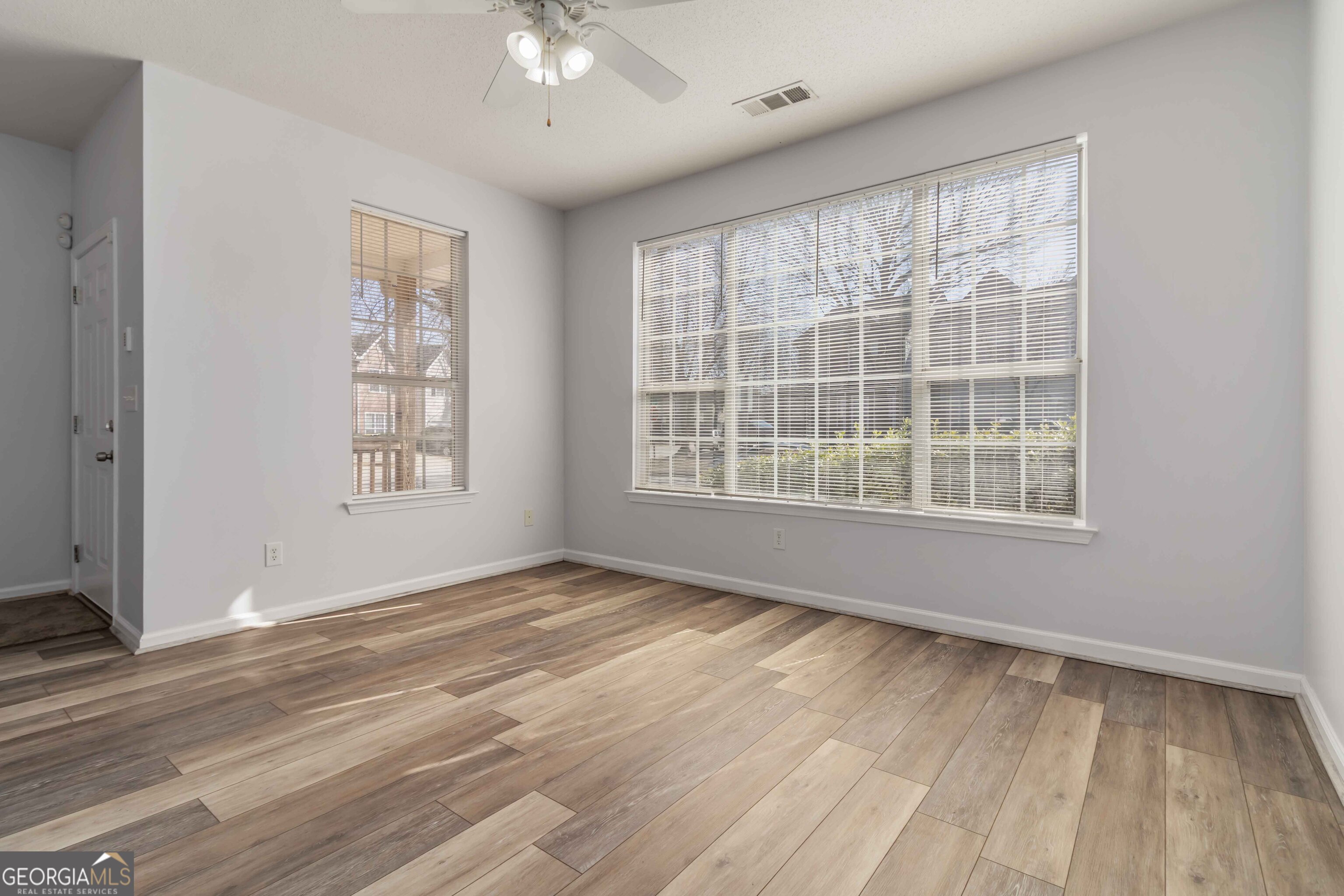 11307 Michelle Way Hampton, GA 30228 - Photo 8 of 30 a view of an empty room with a window and wooden floor