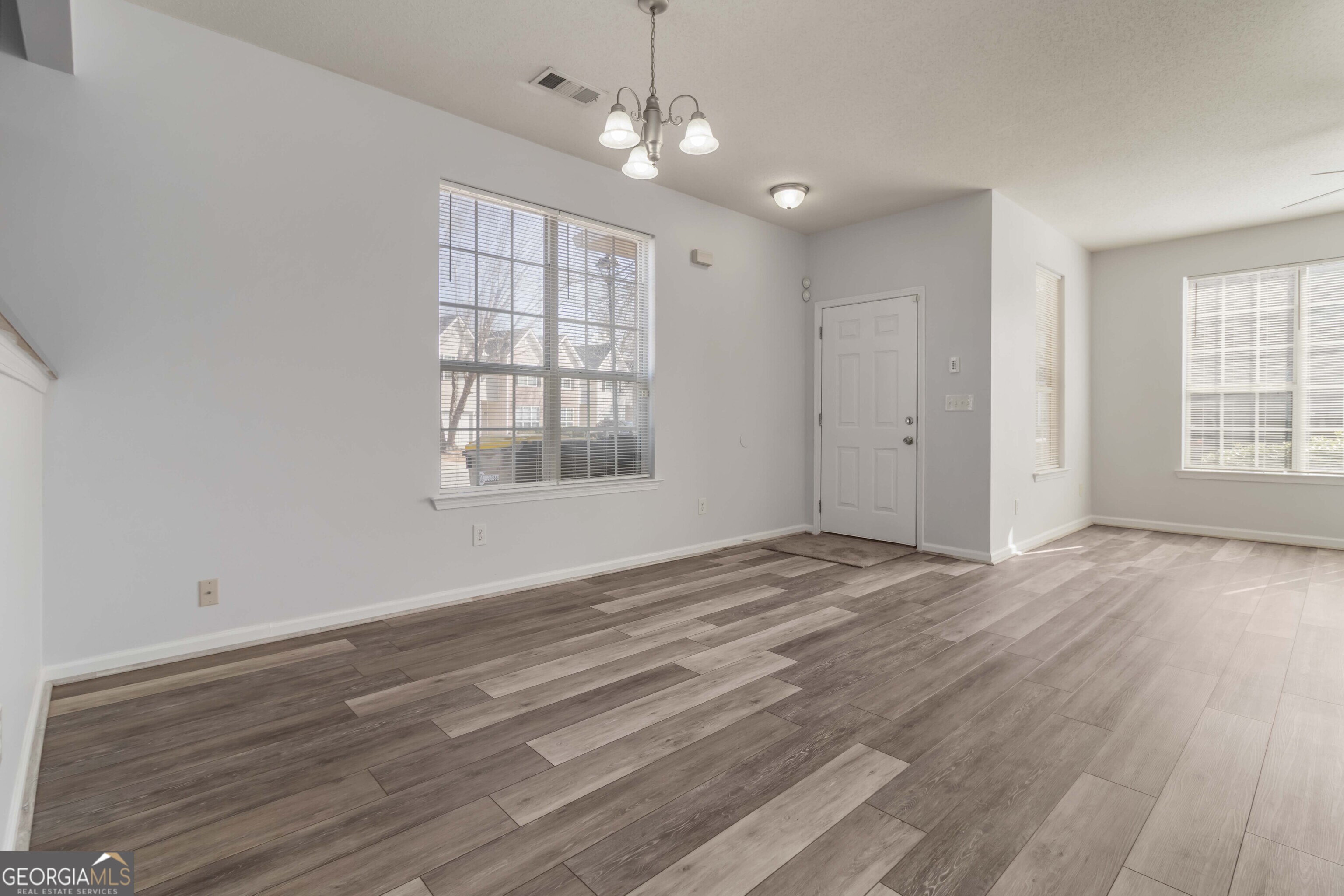 11307 Michelle Way Hampton, GA 30228 - Photo 9 of 30 a view of an empty room with wooden floor and a window