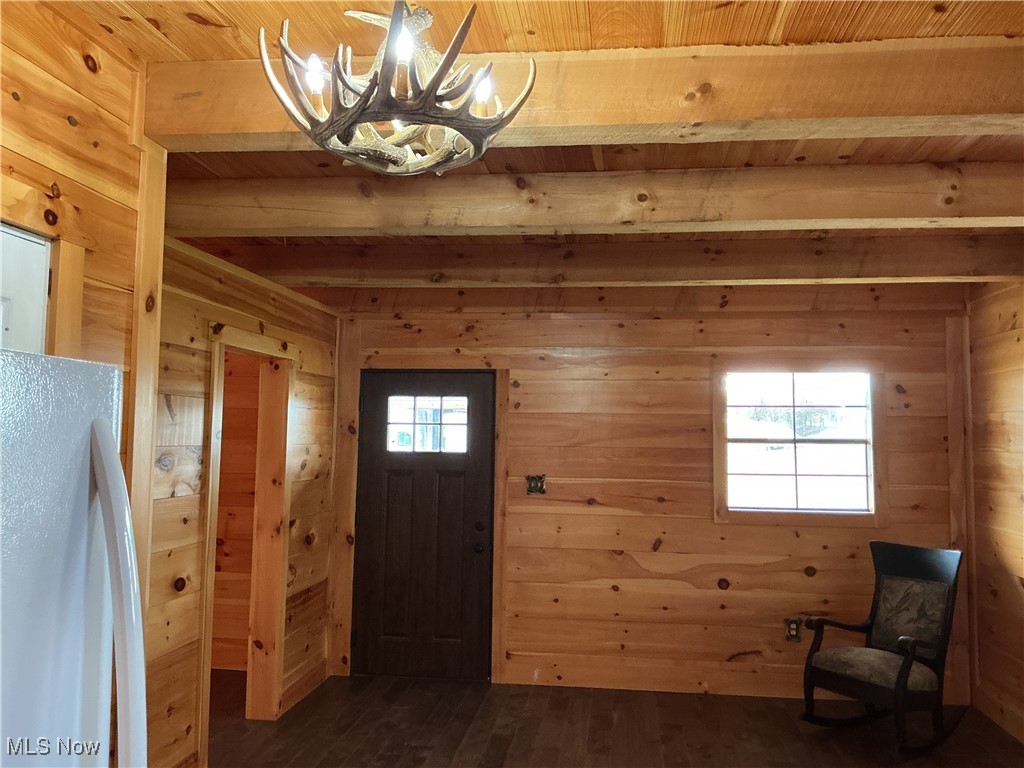 10550 Symmes Creek Road Adamsville, OH 43802 - Photo 14 of 21 Entrance foyer with wooden walls, dark wood-style floors, healthy amount of natural light, a wood ceiling with exposed beams, and a chandelier