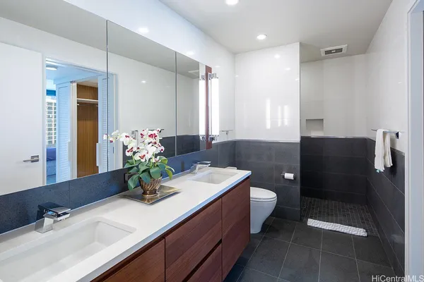 a bathroom with a sink a large mirror and a shower