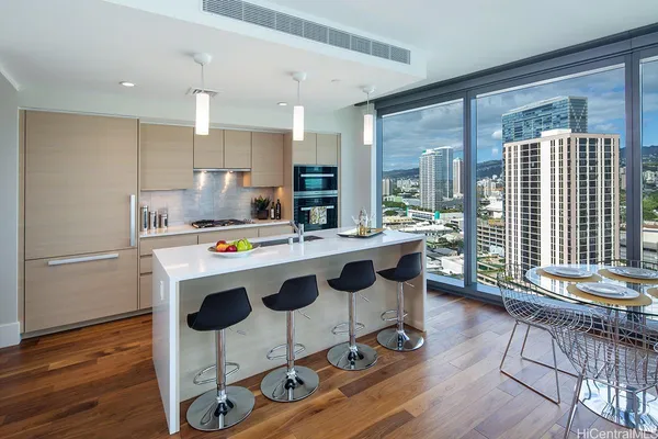 a kitchen with kitchen island granite countertop a stove a sink a dining table and chairs