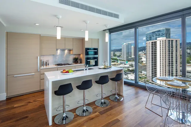 a kitchen with kitchen island granite countertop a stove a sink a dining table and chairs