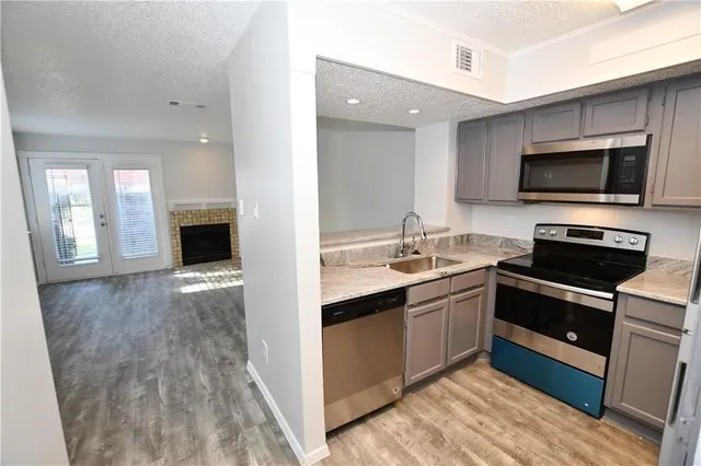 a kitchen with stainless steel appliances granite countertop a stove top oven and sink