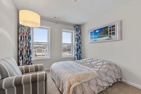 a bedroom with a bed couch and window