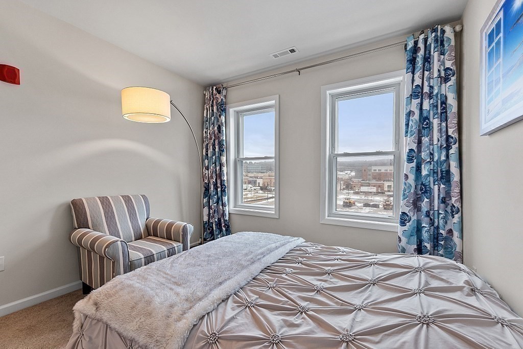 120 University Avenue, Unit 2308 Westwood, MA 02090 - Photo 13 of 20 a bedroom with a bed and wooden floor